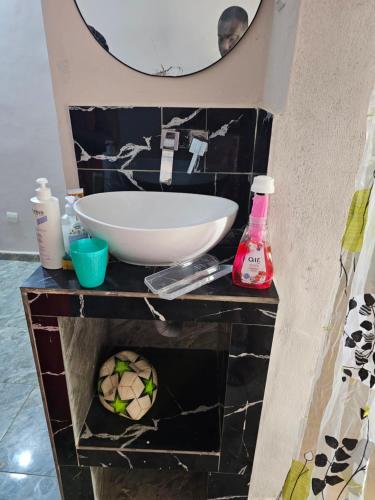 a bathroom with a sink and a mirror at Home RÉSIDENCE OUIDAH in Ouidah
