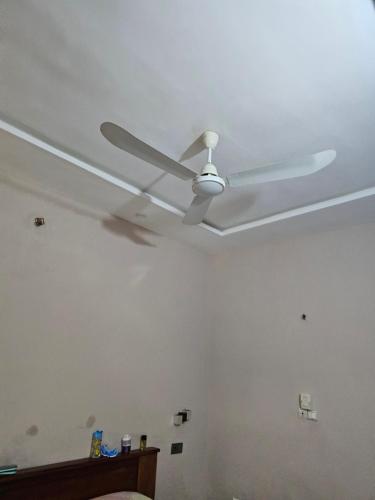 a white ceiling fan in a room with a bed at Home RÉSIDENCE OUIDAH in Ouidah