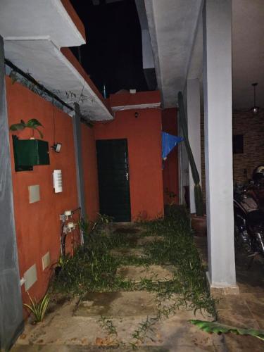 a house with an orange wall and a door at Home RÉSIDENCE OUIDAH in Ouidah