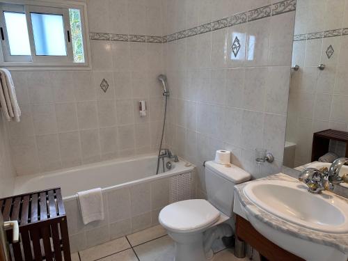 a bathroom with a sink and a toilet and a bath tub at Hôtel Résidence Le Phoenix in Saint-Pierre
