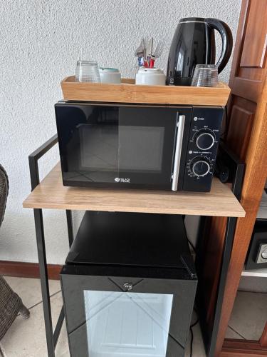 a microwave sitting on top of a computer on a table at Hôtel Résidence Le Phoenix in Saint-Pierre
