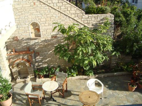 a patio with tables and chairs and a fireplace at Green Hill Studios & Apartments in Kokkari