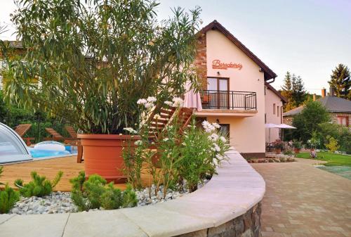 a house with a staircase in front of it at Barackvirág Apartmanház in Tihany