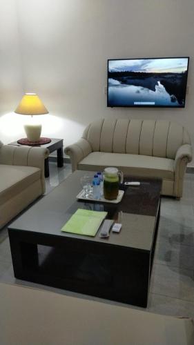 a living room with a couch and a coffee table at Airport Layover Family Lodge in Islamabad