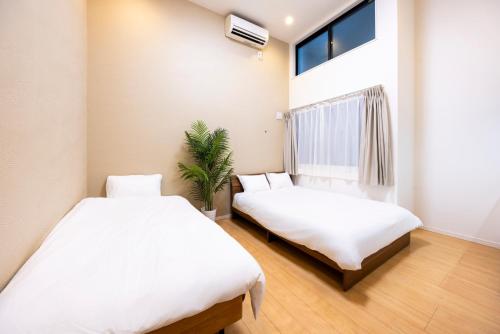 a bedroom with two beds and a window at LOOP Shimogofuku in Fukuoka
