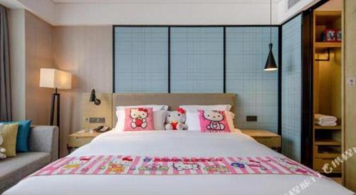 a bedroom with a large bed with hello kitty pillows at Echarm Hotel Nanning Chaoyang Square River View in Nanning