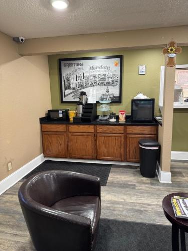 una sala d'attesa con una sedia in pelle e un bancone di Super 8 by Wyndham Mendota I-39 a Mendota