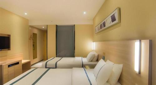 a large bedroom with two beds and a television at City Comfort Inn Liuzhou High-speed Railway Station in Liuzhou