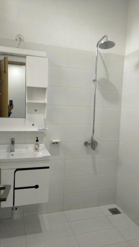 a white bathroom with a shower and a sink at Airport Layover Family Lodge in Islamabad