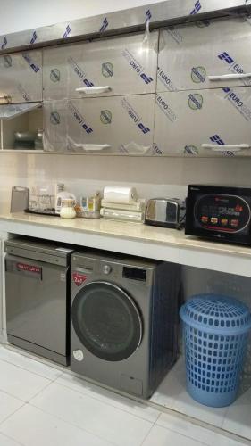 a kitchen with a stove and a microwave at Airport Layover Family Lodge in Islamabad