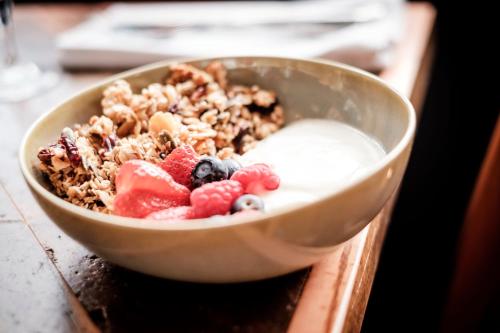 a bowl of yogurt and fruit on a table at The Queen's Head in Kingston upon Thames