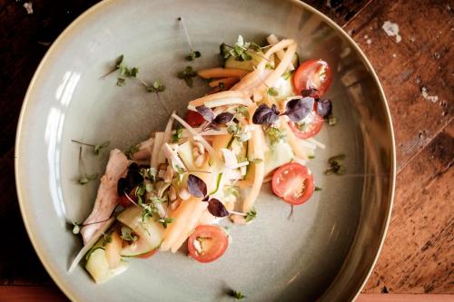 a plate of food with tomatoes on a table at The Queen's Head in Kingston upon Thames