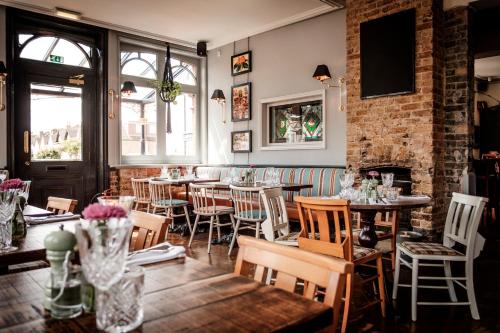 a restaurant with tables and chairs and a brick wall at The Queen's Head in Kingston upon Thames