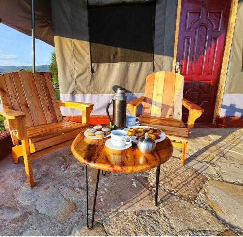 a table and two chairs and a table with food on it at Endeem mara resort in Ololaimutiek