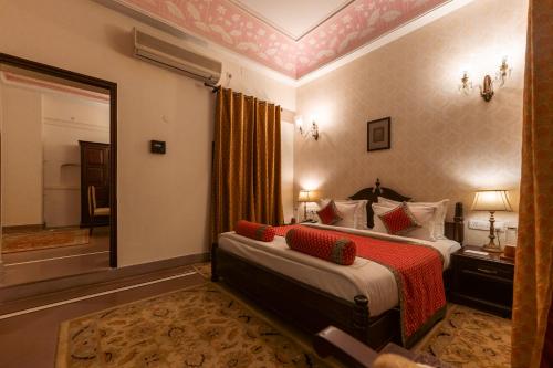a hotel room with a bed and a large mirror at BrijRama Palace, Varanasi - By the Ganges in Varanasi