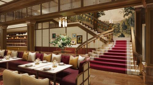 a restaurant with two tables and a staircase at Londoner Grand, a Luxury Collection Hotel, Macau in Macau