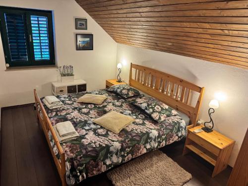 ein Schlafzimmer mit einem Bett mit einem hölzernen Kopfteil in der Unterkunft Villa Monica in Ložišće