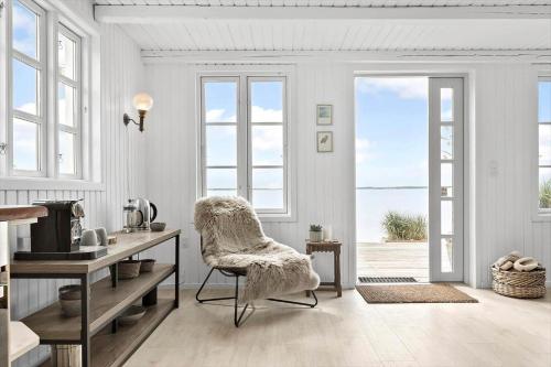 a white living room with a chair and a desk at 8113-Ronde-Strandvejen-91 in Rønde