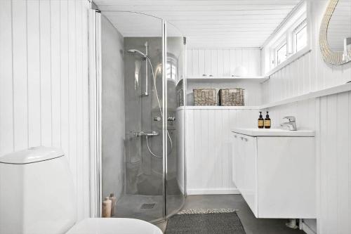 a white bathroom with a shower and a toilet at 8113-Ronde-Strandvejen-91 in Rønde