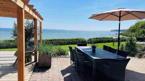 a patio with a table and an umbrella at 8113-Ronde-Strandvejen-91 in Rønde