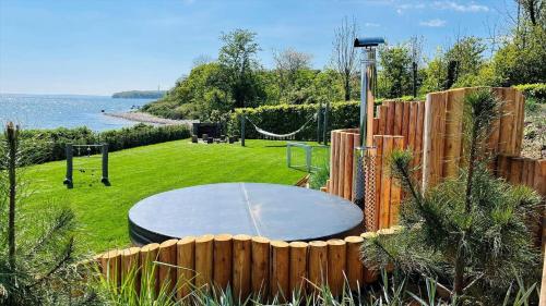 a circular table in a garden with a fence at 8113-Ronde-Strandvejen-91 in Rønde