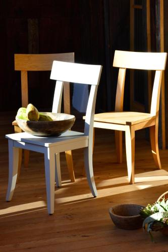 two chairs and a bowl of fruit next to a chair at Apartments Mitterhof 1544 in Brunico