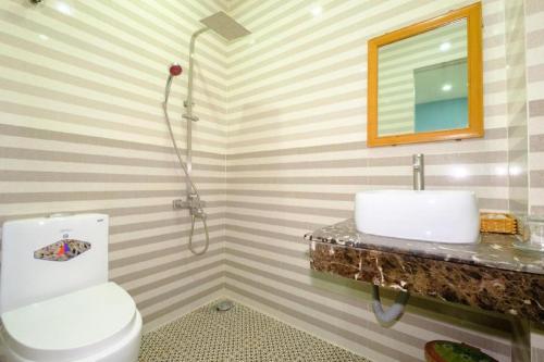 a bathroom with a toilet and a sink at Bluesea Hotel Quy Nhon in Quy Nhon