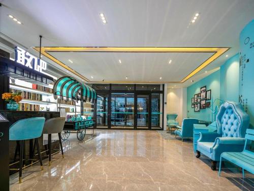 a lobby with blue chairs and a bar in a building at Xana Lite Hotelle Yan'an Baota Mountain in Yan'an