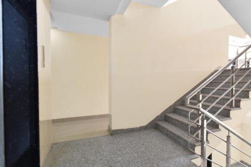 a staircase in a building with a white wall at Hotel O Ashoka in Kota