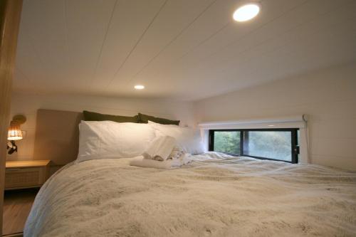 a white bed with a stuffed animal on top of it at Kookaburra's Perch in Millgrove