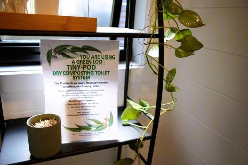a shelf with a sign and a plant on it at Kookaburra's Perch in Millgrove
