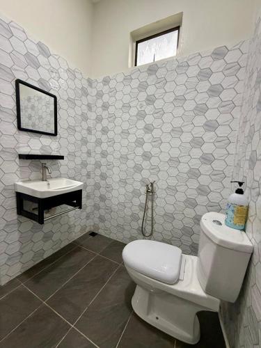 a bathroom with a toilet and a sink at Aman Homestay, Marang in Marang