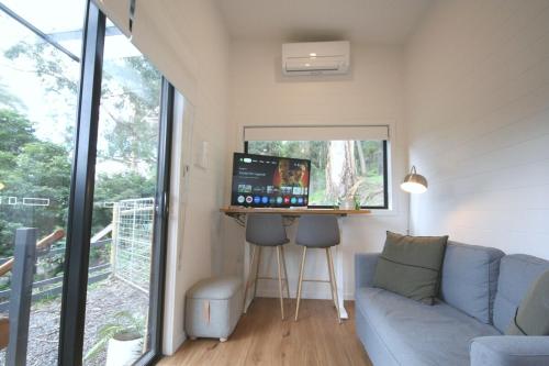 a living room with a couch and a desk with a computer at Kookaburra's Perch in Millgrove