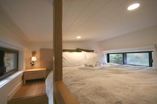 ein Schlafzimmer mit einem großen weißen Bett mit einem Fenster in der Unterkunft Kookaburra's Perch in Millgrove