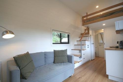 a living room with a blue couch and a kitchen at Kookaburra's Perch in Millgrove