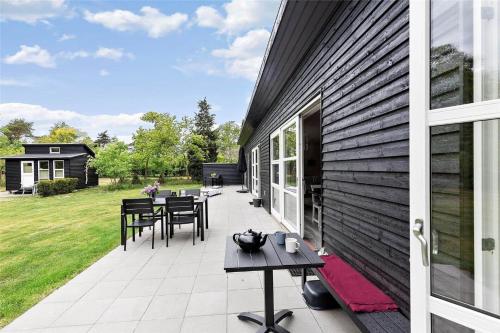 a patio with tables and chairs next to a building at 8245-Knebel-Metholmvej-9 in Knebel
