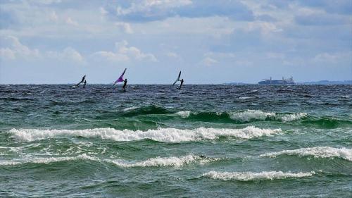 three people are wind surfing in the ocean at 8245-Knebel-Metholmvej-9 in Knebel