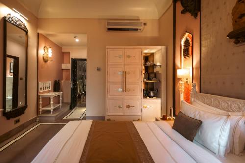 a bedroom with a large bed and a mirror at BrijRama Palace, Varanasi - By the Ganges in Varanasi