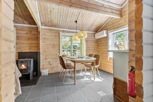 a dining room with a table and a fireplace at 84144-Ronde-Noddevej-22 in Rønde