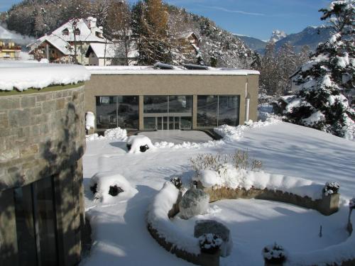a yard covered in snow with a building at Hotel Bemelmans-Post in Collalbo