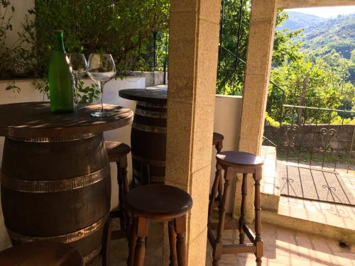 a bar with stools and a window with wine bottles at Retiro Da Arminda in Canedo