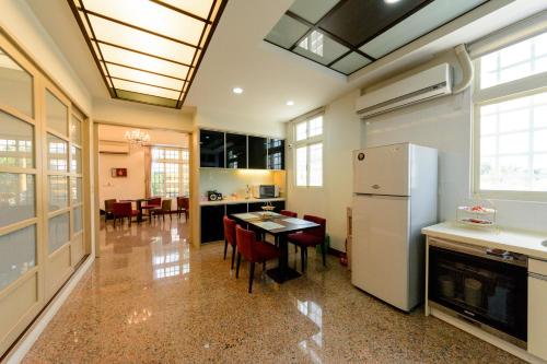 a kitchen with a table and a refrigerator at Hualien Macaron B&B in Ji'an