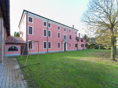 a large red building with a basketball hoop in the yard at Pet-Friendly Nature Escape in Pontecchio Polesine