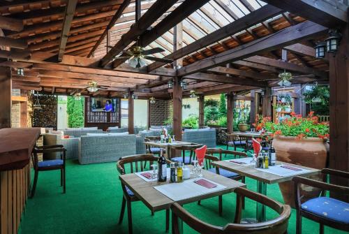 a restaurant with wooden ceilings and tables and chairs at Grand Częstochowa in Częstochowa