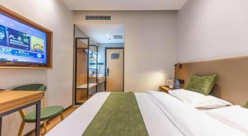a bedroom with a large bed and a tv at GreenTree Inn Express Lanzhou West Passenger Station Lanzhou Center in Lanzhou