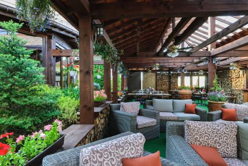 an outdoor patio with couches and tables and flowers at Grand Częstochowa in Częstochowa