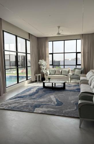 a living room with couches and a large rug at Violet Chalett in Jalan Bani Buali