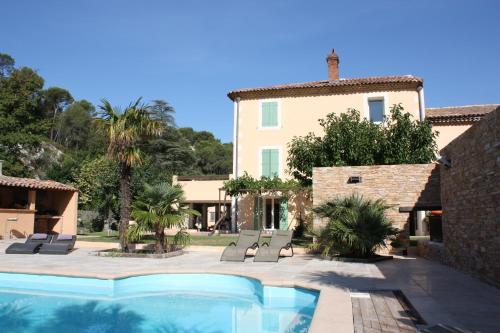 une villa avec piscine devant une maison dans l'établissement B&B Le Manoir De Gemenos, à Gémenos