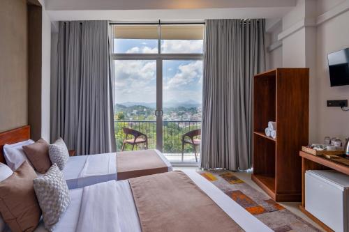 a hotel room with a bed and a large window at 360 Viewpoint by Queens Mount in Kandy
