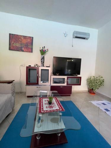 a living room with a glass table and a tv at Domus Komanesse - Guest Houses in Koman